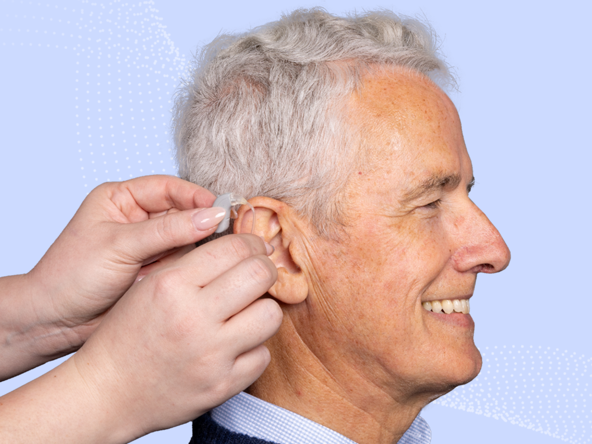 a person putting ear plugs on a man's ear