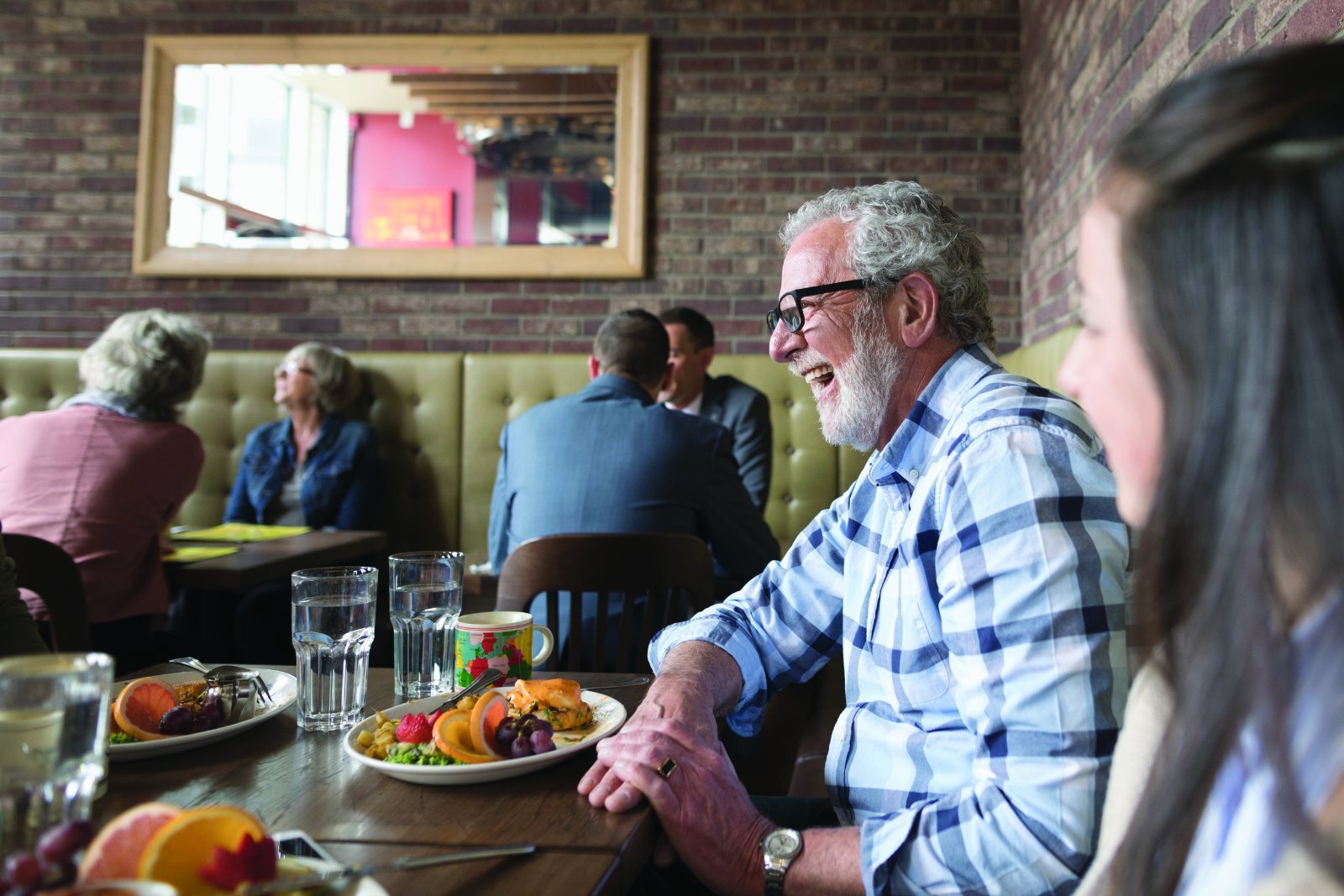 Man using intelligent hearing aid in a restaraunt