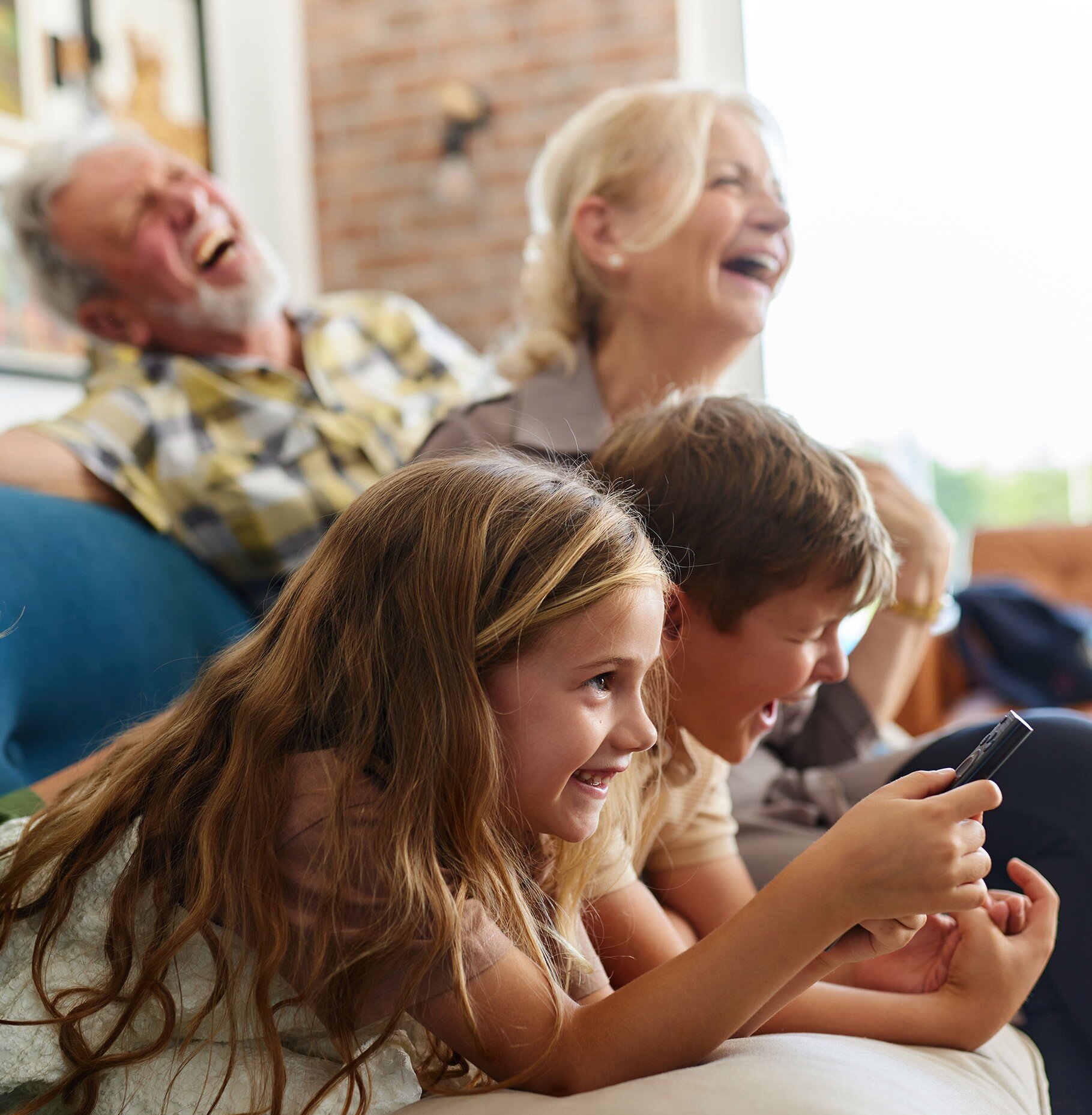 a group of people laughing while playing on a phone