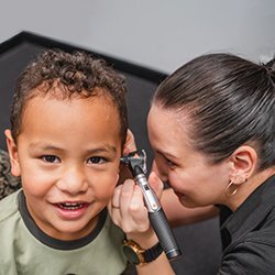 Hearing Australia audiologist conducting a hearing test with a young child patient in a friendly clinical setting