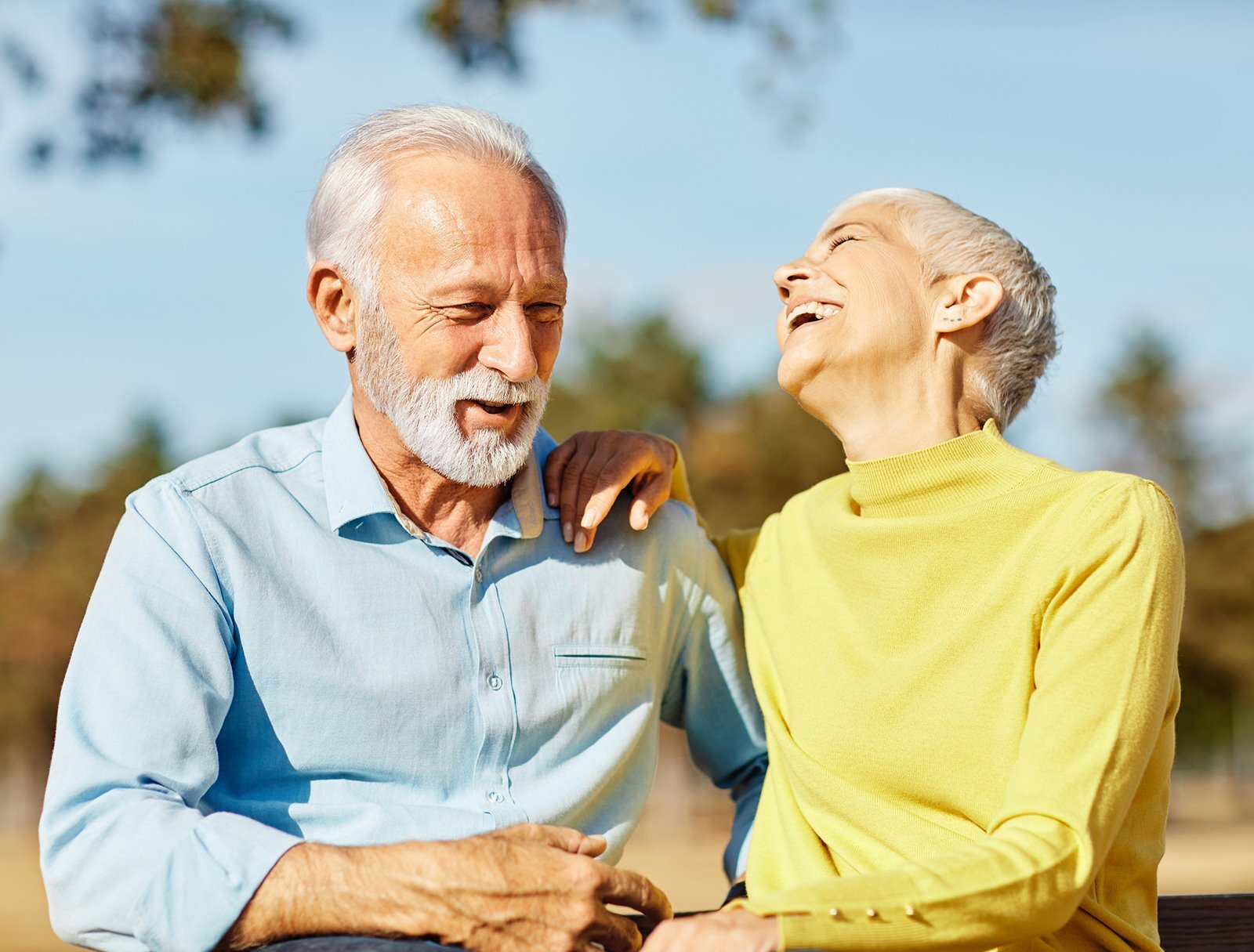 two adults smiling joyfully, sharing a happy moment together