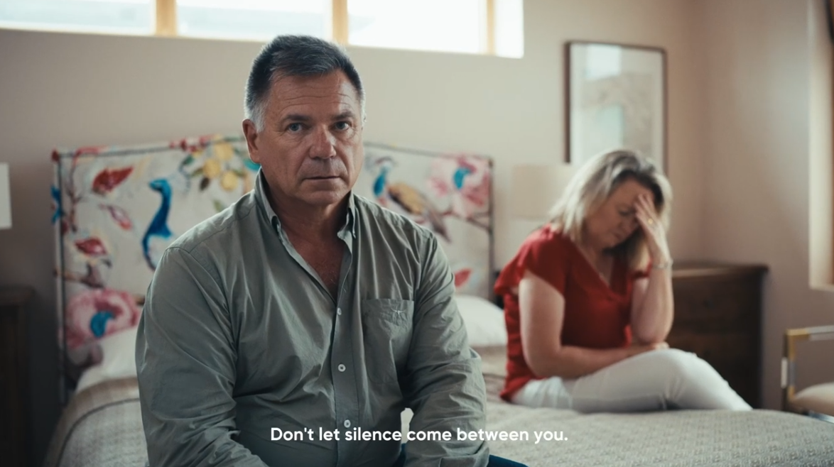 a man sitting on a bed with a woman sitting on the bed