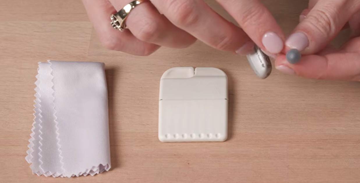 a hand holding a small white object