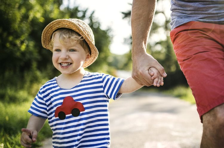 a child smiling and happily holding a hand