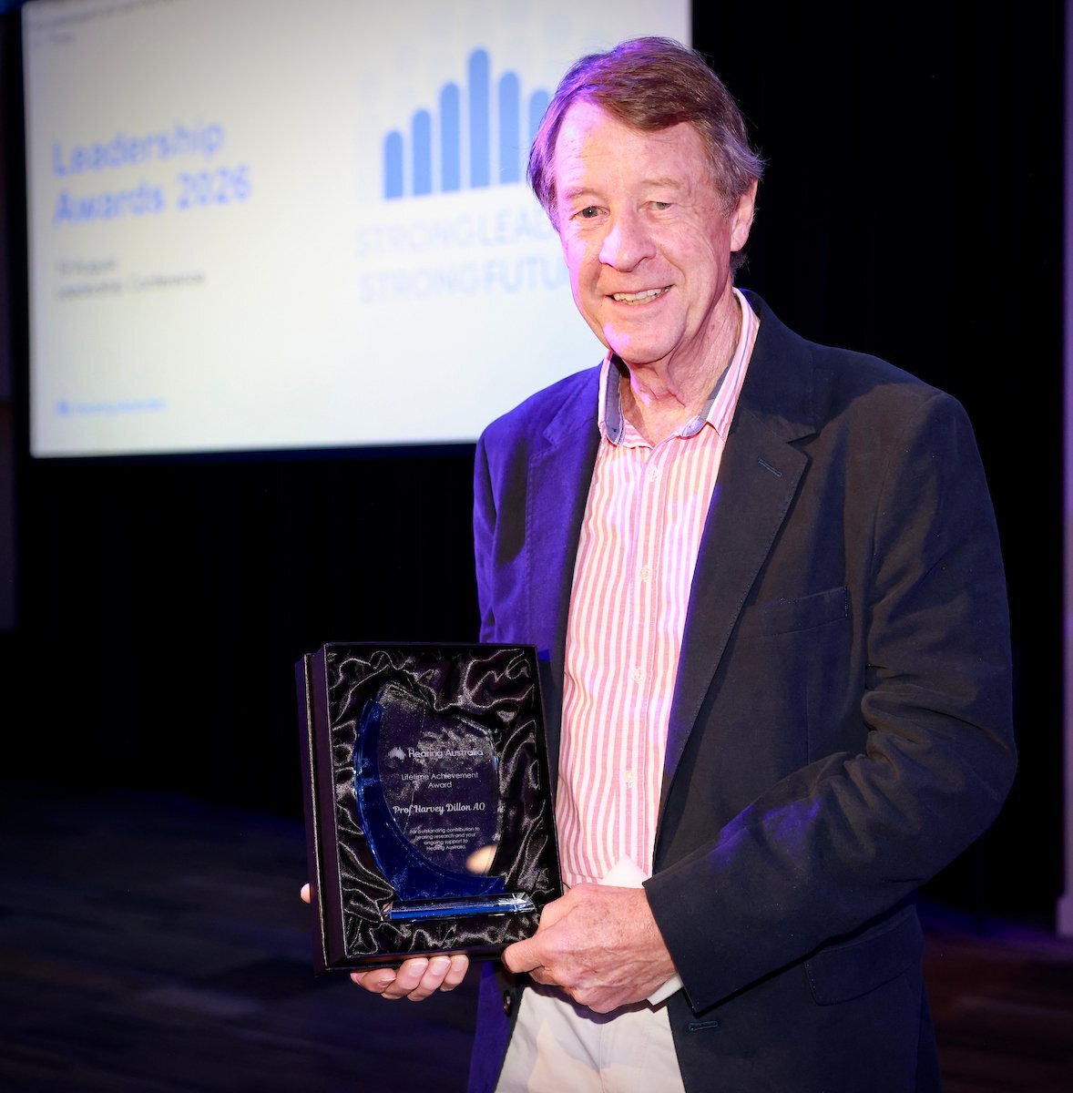 Professor Harvey Dillon holding lifetime achievement award