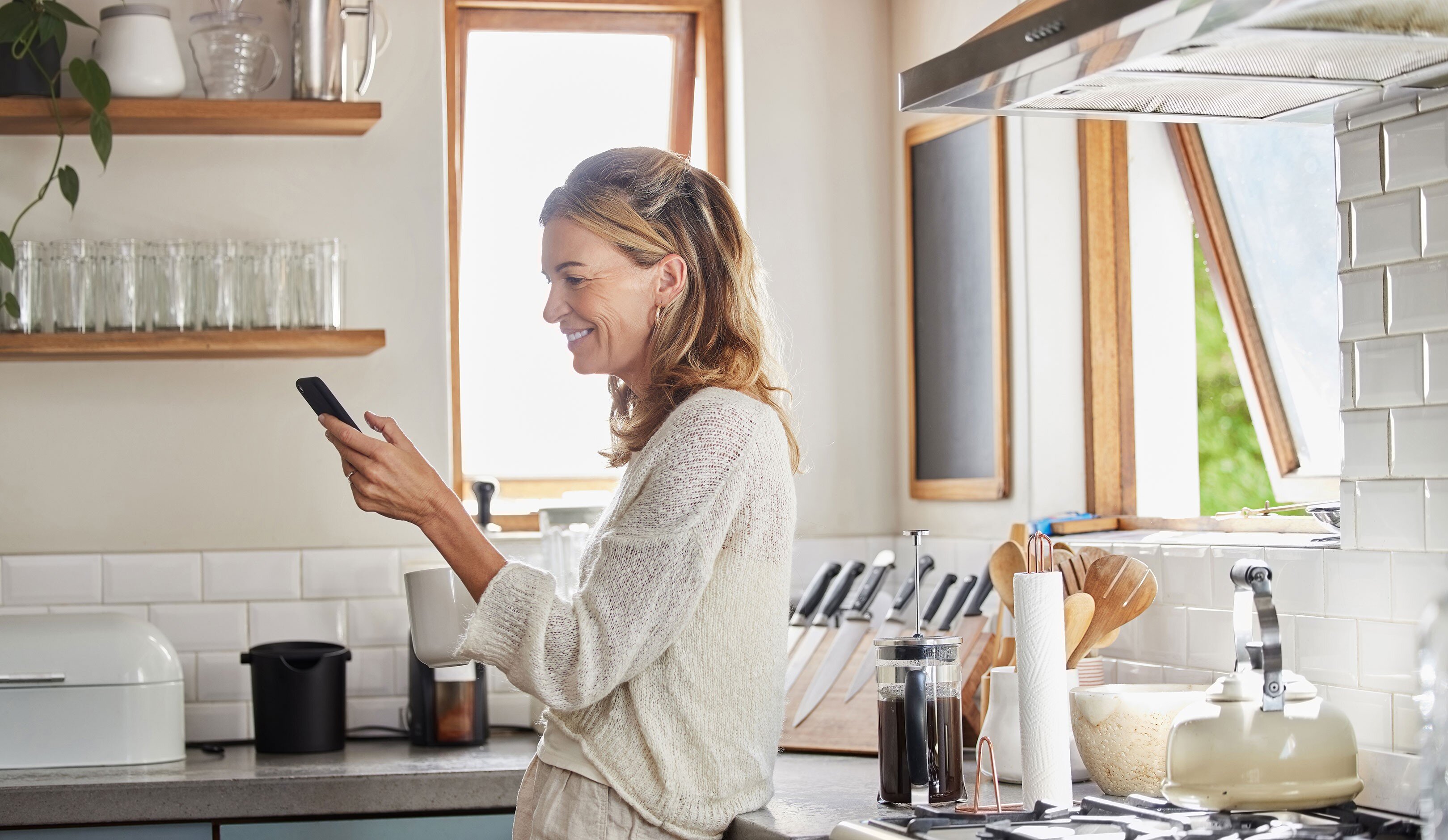 a woman smiling while holding a phone