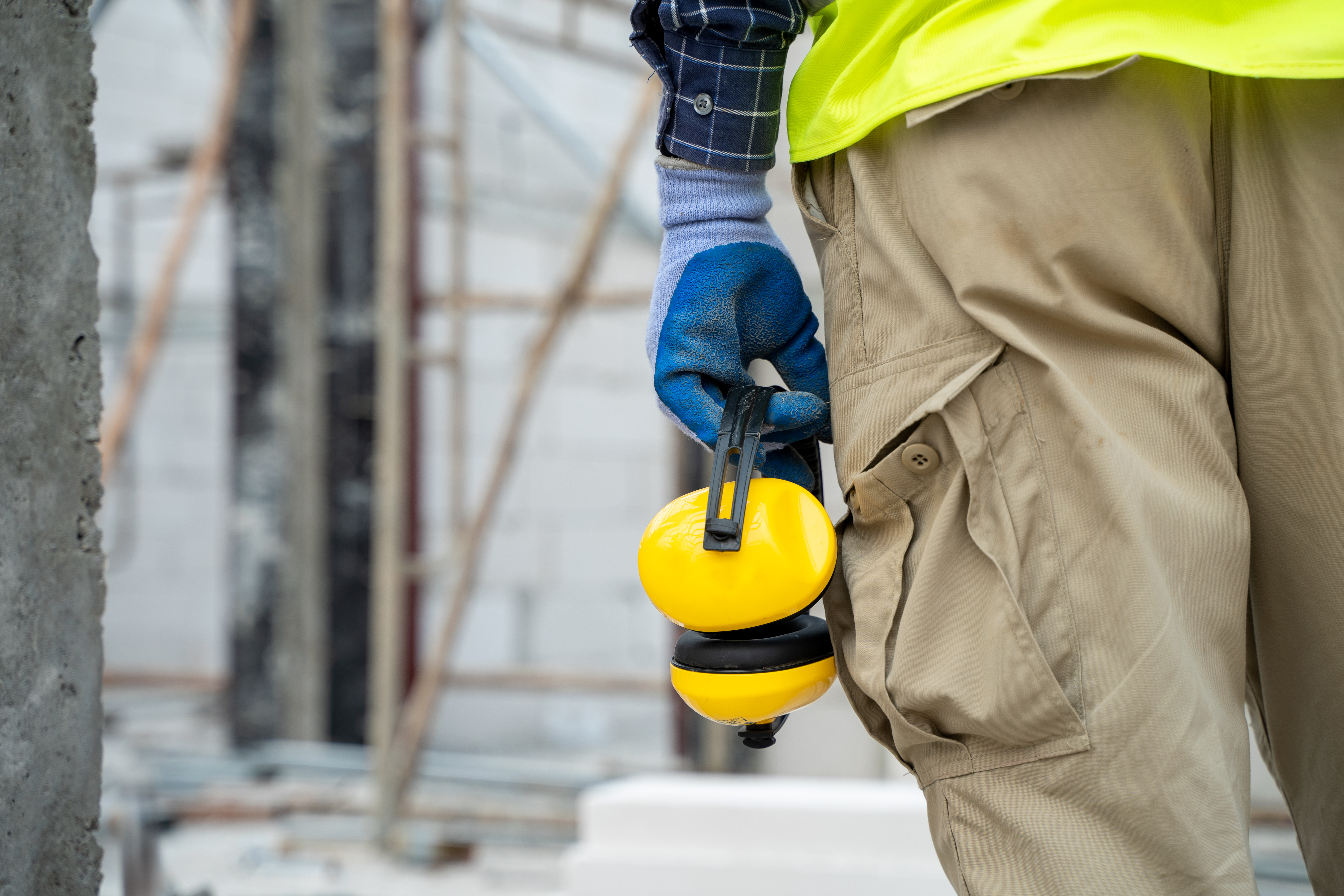 Construction worker holding hearing protection