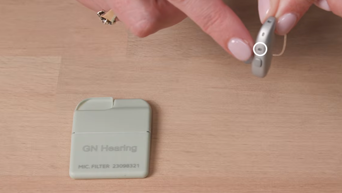 a hand holding a hearing aid