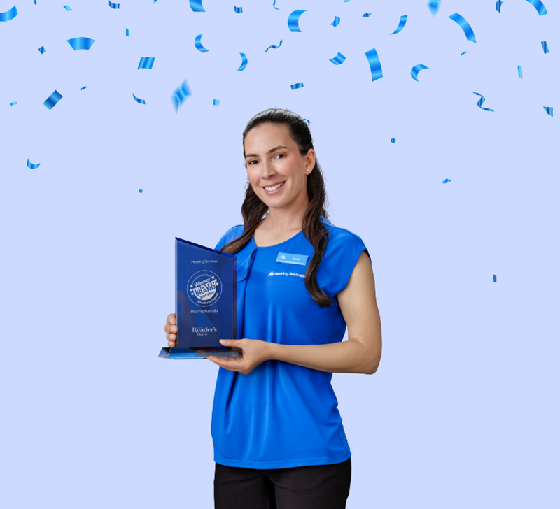 Hearing Australia staff proudly holding the Australia's Most Trusted Hearing Provider award, smiling and celebrating their achievement.