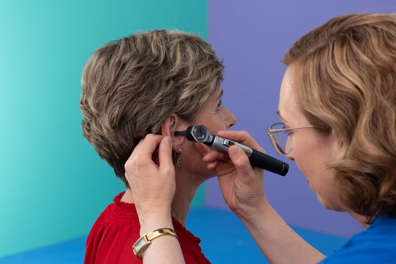 An audiologist gives a female client an assessment